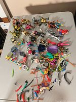 Tabletop view showing approximately 30 action figures and large assortment of weapons and accessories