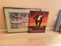 Both framed artworks leaning against wall