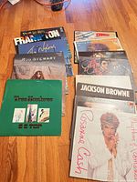 Stack of vinyl records fanned out on hardwood floor