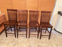 Front view of all four matching wooden bar stools
