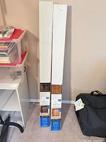 Both boxed Roman shades standing upright showing brand and size.