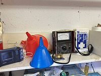 Shelf with Casio TV, funnels, Sanwa multimeter, first aid kit, string spool