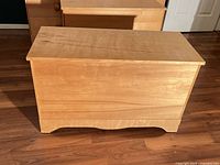Front view of light maple storage chest closed
