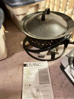 Overall view of fire bowl with lid, hose, and manual