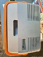 Top view of Mobicool cooler showing handle cut-out, vents, orange rim, brand label