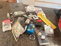 All items laid out on countertop including Hang & Level tool, timers, hardware kit, wire spool, packaged digital and analog timers