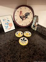 Clock, thermometer, three plaques and trivet displayed on countertop