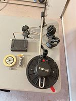 Full view of Scotty manual downrigger, mounting base, cable spool and hardware on table