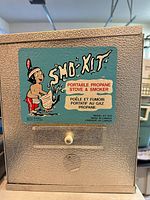 Front view of SMO-KIT stove showing label and latch