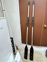 Full view of both assembled paddles leaning against door