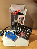 Lot overview showing charger, torque adapter box, OBD2 scanner packaging