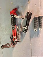 Red Spirit Beast adjustable side kickstand, black bracket, two rubber foot pegs mounted on wall