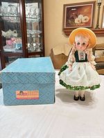 Doll standing beside original patterned box