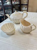 Full view of three-piece Belleek Neptune tea set on table