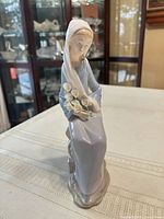 Front view of Lladró figurine showing seated woman with lilies