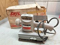 Skil Model 490 sander front view with power cord and original box behind