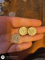 Three 1951 Canadian 5-cent coins held in hand showing obverse design