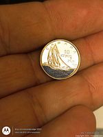 Reverse of colorized Bluenose dime showing schooner and blue water