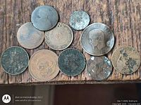 Top view of 11 worn copper coins on wood surface