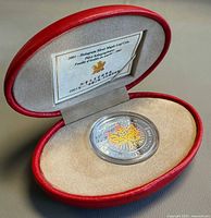 Coin in capsule inside red presentation case with insert card