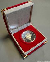 Coin in open red velvet Royal Canadian Mint clamshell case