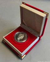 Coin in red RCM presentation case, lid open