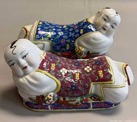 Both porcelain pillow figurines side by side showing front and side details