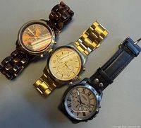 Three watches laid out: Michael Kors (top), Guess (middle), Fossil (bottom)