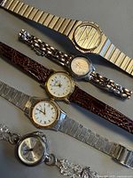 Five watches displayed front view showing dial designs and bands