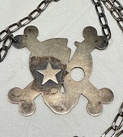 Close rear view of pendant showing 925 hallmark and surface wear