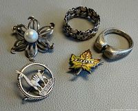 Five silver jewellery pieces displayed