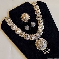 Set displayed on black stand showing necklace, brooch and earrings