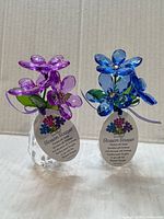 Front view of both purple and blue Blossom Bouquet figurines