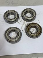 Four 6206Z ball bearings on paper showing both faces