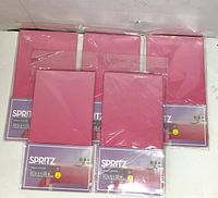 Six packaged Spritz pink ombre table covers arranged on surface