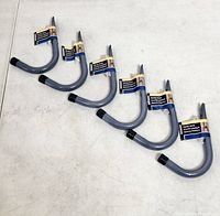 Six identical Stinson Handy Hook wall hooks lined up on table