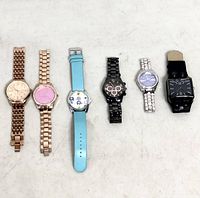 All six wristwatches laid out side by side