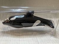 Left side view of killer whale flute in package