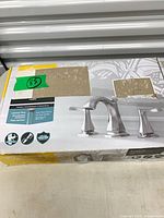 Sealed retail box showing faucet image and included components