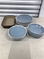 Stacked blue stoneware plates and bowls with rectangular baking dish