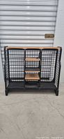 Front view of black metal grid golf bag shelf unit with wood shelves