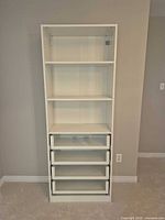 Front view showing full height shelving unit with three shelves and four drawers