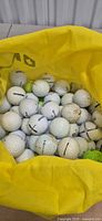 Top view of yellow tote filled with mixed golf balls