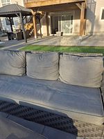 Front view of dark grey wicker 3-seat sofa with mid-grey cushions