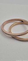 Two rose gold bangles stacked, showing crystal pave detail