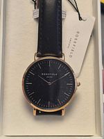 Watch in presentation box showing face, strap, hang tag