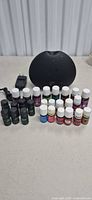 Diffuser, adapter, and 24 essential oil bottles displayed on table