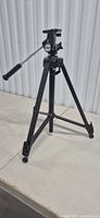 Tripod standing, legs partially extended, pan/tilt head visible