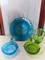 Overall group shot of four pressed glass pieces