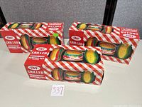 Three red-gingham Boston Warehouse boxes displayed